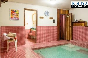 een rood betegelde badkamer met een zwembad bij Chateau Bernina in Lake Arrowhead