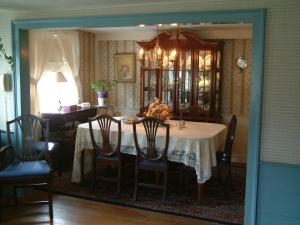 a dining room with a table and chairs and a window at Truman Gillet House B & B in Granby