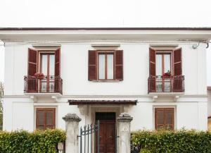 een wit huis met 2 balkons en een deur bij Villa Del Poeta in Sulmona