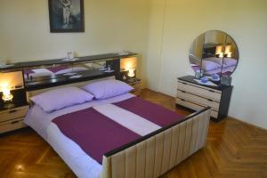 um quarto com uma cama grande e um espelho em Marin Apartment em Bibinje