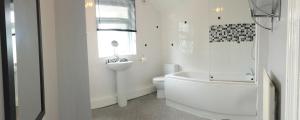 ein Badezimmer mit einer Badewanne, einem WC und einem Waschbecken in der Unterkunft Royle House by SG Property Group in Northwich