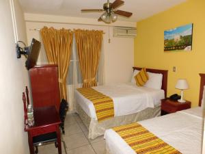 a hotel room with two beds and a window at Hotel San Jose Hostal in San Salvador +110 photos