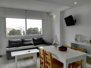 - un salon avec un canapé et une table dans l'établissement Vista Roses Mar - Apartamento con Piscina, à Roses