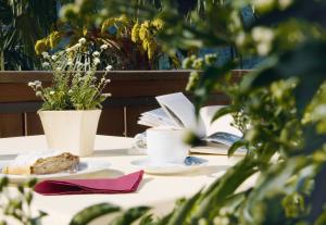 una mesa con dos platos de comida y un libro en Hotel Kronsbühel, en Tirolo 12 fotos más