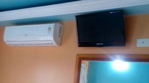 a television and a air conditioner on a wall at Hotel Golf II in Sao Paulo