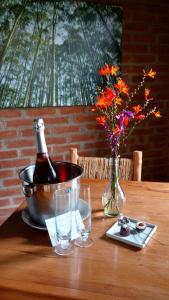 a bottle of wine and flowers on a wooden table at Pousada Pinho Bravo in Camanducaia +245 photos