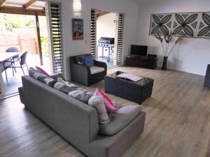 a living room with two couches and a television at Muri Beachside Villa with pool in Rarotonga