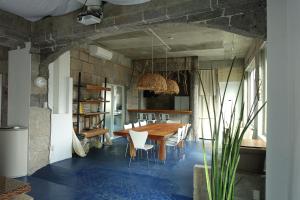a dining room with a wooden table and chairs at Hostel NABLA in Niijimamura