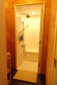 a walk in shower in a bathroom with a shower stall at Hostel NABLA in Niijimamura +12 photos