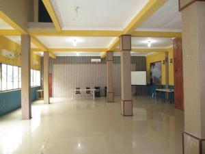 un gran salón con columnas y mesas en un edificio en Permata Land Hotel & Resort, en Rantauprapat
