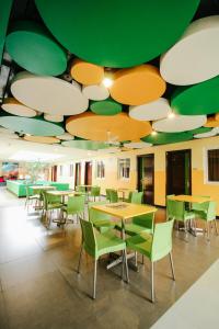 a cafeteria with tables and chairs under a green and white ceiling at Go Hotels Tacloban in Tacloban