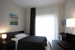 um quarto de hotel com uma cama e uma janela em Guest House Residence em Messina