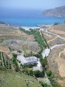 una vista aérea de un edificio en una colina junto al océano en Ammoudi Hotel, en Damnoni