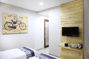 a bedroom with a bike painting on the wall at Omah Njonja Bed & Brasserie in Yogyakarta