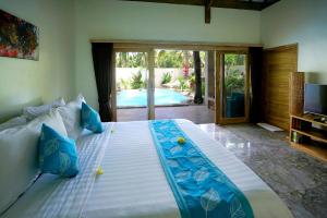 a large bed in a room with a pool at Senang Private Villa in Gili Trawangan