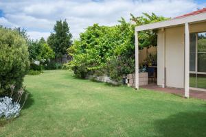 un patio con césped verde y árboles y una casa en Bellevue Bed & Breakfast en McLaren Vale