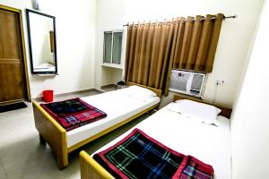 a room with two beds and a mirror at Hotel Akashdeep in Rānchī