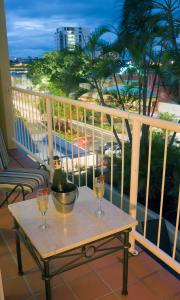 凱恩斯的住宿－凱恩斯酒店，阳台上的桌子上放了两杯葡萄酒