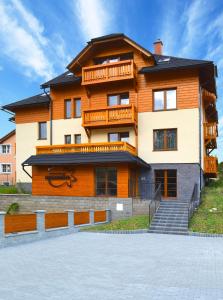 a large building with a staircase in front of it at Penzion Sasanka in Oščadnica