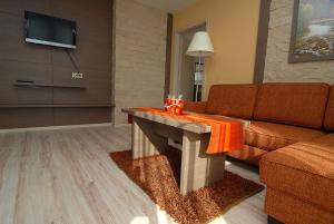 ein Wohnzimmer mit einem Sofa und einem Tisch in der Unterkunft Penzion Sasanka in Oščadnica