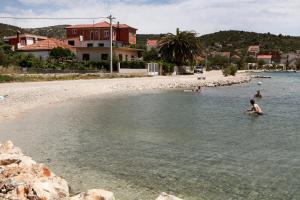 a group of people in the water on a beach at Apartment Ivan in Vinišće