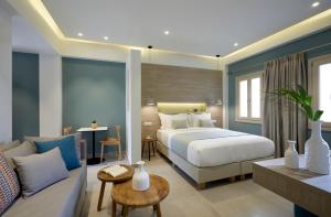 1 dormitorio con 1 cama y sala de estar con sofá en Fileria Suites, en Oia