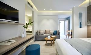 a hotel room with a bed and a couch at Fileria Suites in Oia