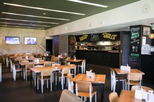 ein Esszimmer voller Tische und Stühle in der Unterkunft Alpha Hotel Eastern Creek in Blacktown