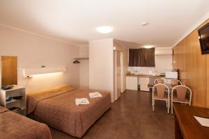 a hotel room with two beds and a kitchen at Jefferys Motel in Toowoomba