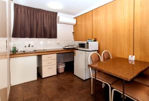 a small kitchen with a table and a microwave at Jefferys Motel in Toowoomba