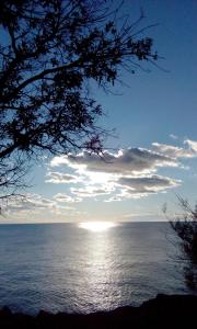 a view of the ocean with the sun in the sky at Apartment Mamut in Premantura