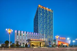 a tall building with lights on the side of it at Wanda Realm Shangrao in Shangrao