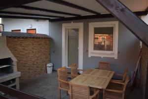 a wooden table and chairs on a patio with a fireplace at Borovnica Čatež in Čatež ob Savi