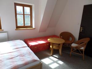1 dormitorio con 1 cama, mesa y sillas en Kralicka Chata, en Ciudad Vieja de Praga
