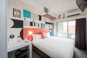 a hotel room with a bed and a desk and a bedroom at Majestic Minima Hotel in Adelaide