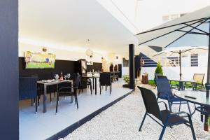 ein Restaurant mit Tischen und Stühlen und einer Terrasse in der Unterkunft Pensiunea Avy in Haţeg