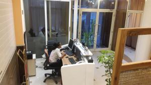un bureau avec deux personnes assises sur un bureau avec un ordinateur dans l'établissement C Fun Addis Hotel, à Addis-Abeba