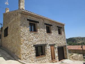 a stone building with windows on the side of it at serranía del tajo in Peñalén