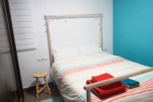 a small bedroom with a bed and a wooden stool at Cozy fisherman's house in Valencia