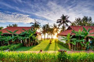 una casa con techo rojo y palmeras en Chen Sea Resort & Spa Phu Quoc, en Phu Quoc