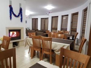 a restaurant with a fireplace and tables and chairs at Yuliya Guest House in Sapareva Banya