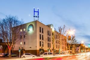 a building with a cross on top of it on a street at Hotel HC*** Mollet Barcelona in Mollet del Vallès