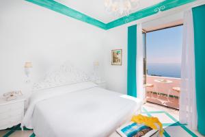 een slaapkamer met een bed en uitzicht op de oceaan bij Villa Flavio Gioia in Positano