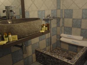 a bathroom with a stone sink and towels at Villa Anastasia in Pefki +37 photos