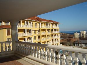 a view of a yellow building from a balcony at Byala Palace Apartments in Byala