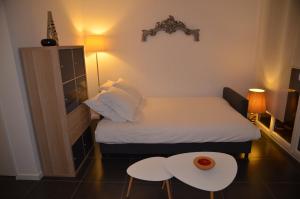 a small bedroom with a bed and two tables at Nice Promenade 1 in Nice