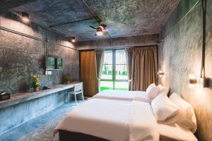 a bedroom with a large bed and a window at Stucco Loft Residency in Chiang Mai +64 photos