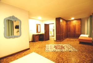 een kamer met een spiegel en een tapijt op de vloer bij Boulevard Inn Mt Meru in Arusha