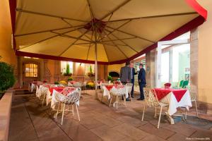 a restaurant with red and white tables and chairs at Hôtel & Spa Le Bouclier D'or in Strasbourg