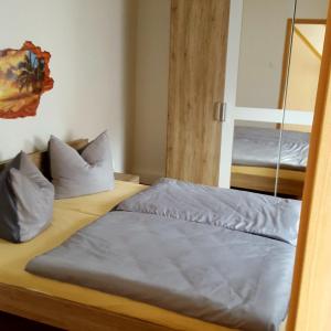 1 Schlafzimmer mit 2 Betten und einem Spiegel in der Unterkunft Ferienwohnung Annett in Böhlen